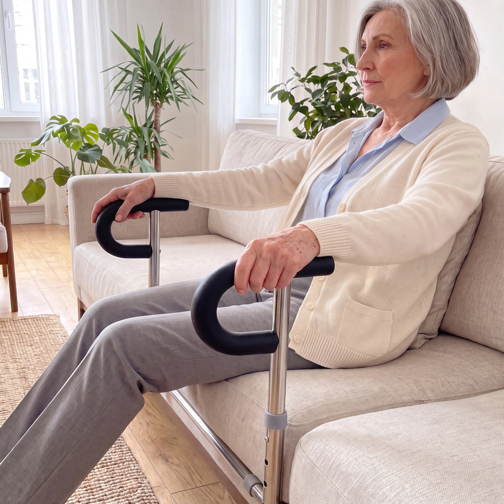 An older woman sitting on her sofa with both hands resting on the SteadyRail padded stand-assist handles